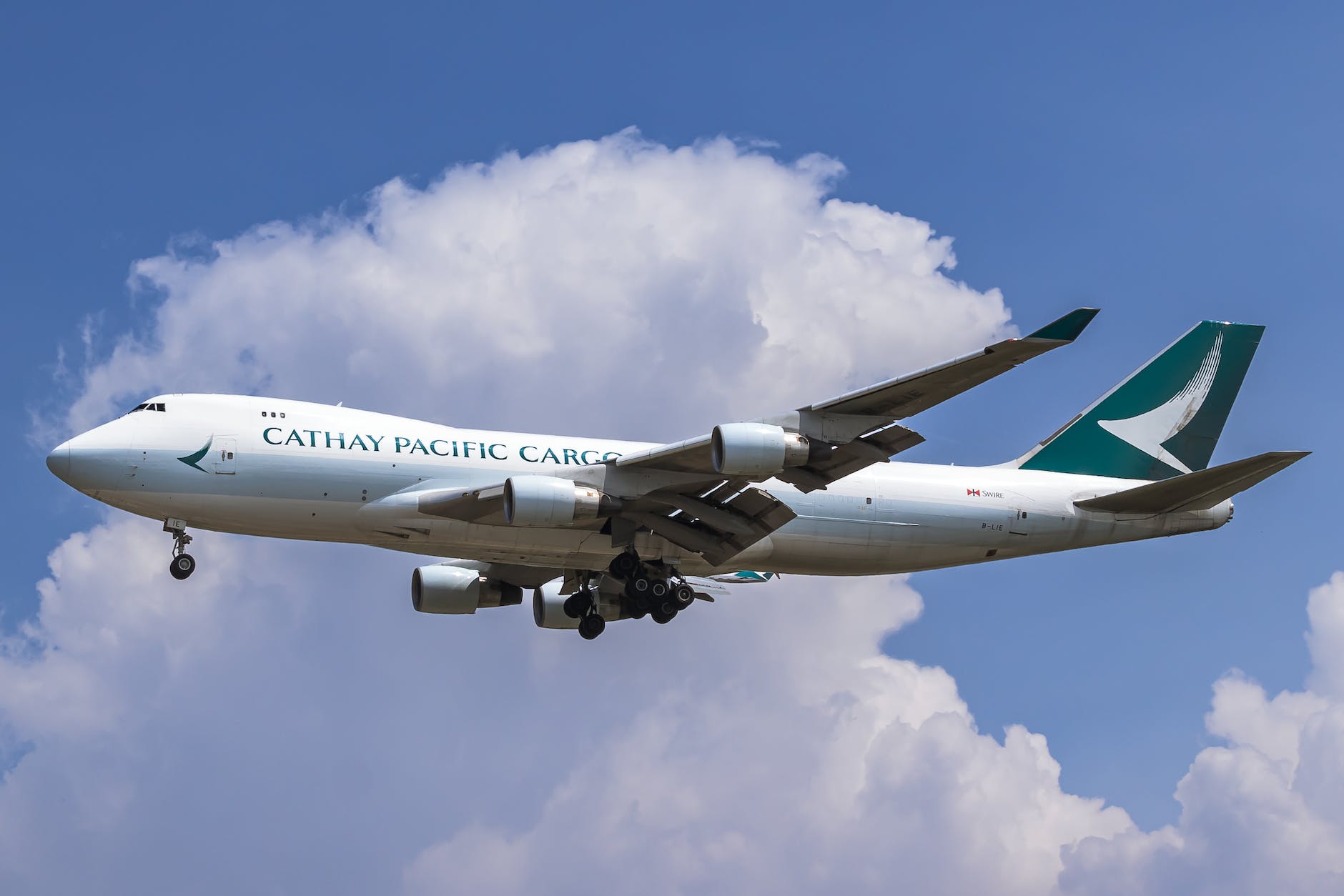 close up photo of a flying cathay pacific airplane