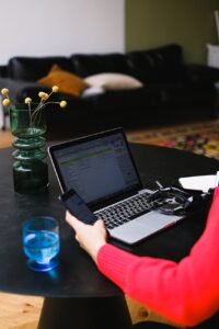 handicapped freelancer using laptop and smartphone in living room